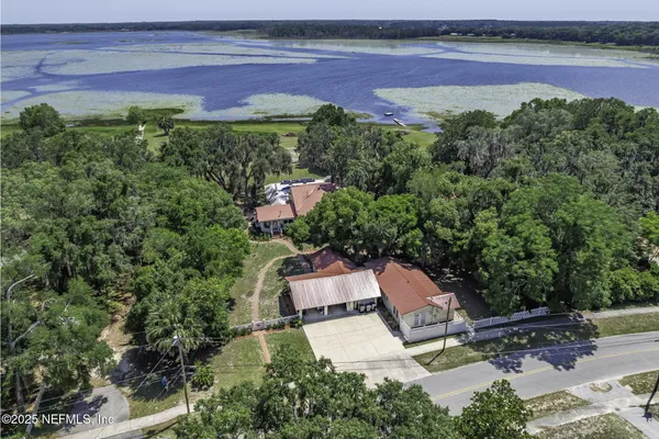an aerial view of a house with a garden and lake view