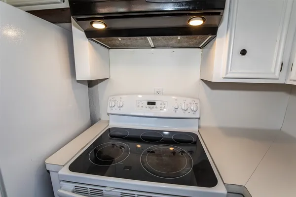 a kitchen with white cabinets and a window