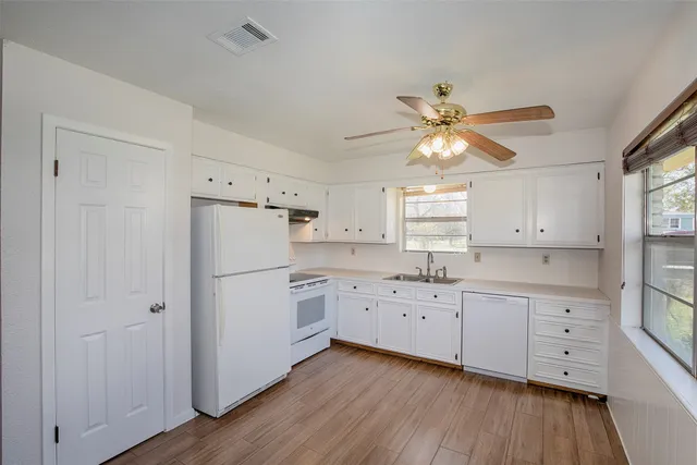 a view of a kitchen with a dishwasher cabinets and wooden floor