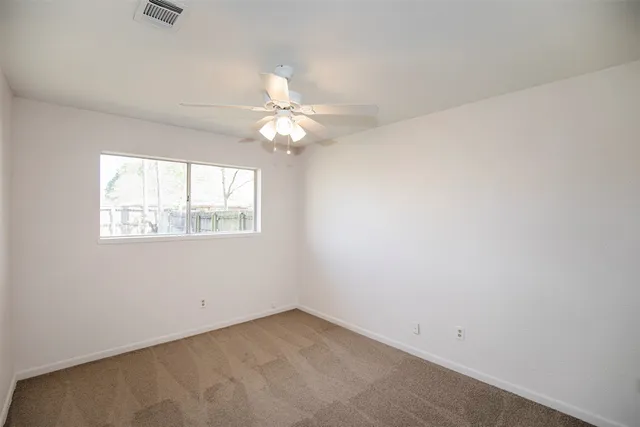 an empty room with a chandelier fan