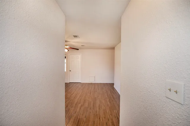 a view of a hallway with wooden floor and closet