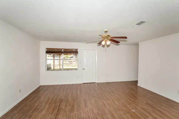 a view of a livingroom with wooden floor and a ceiling fan