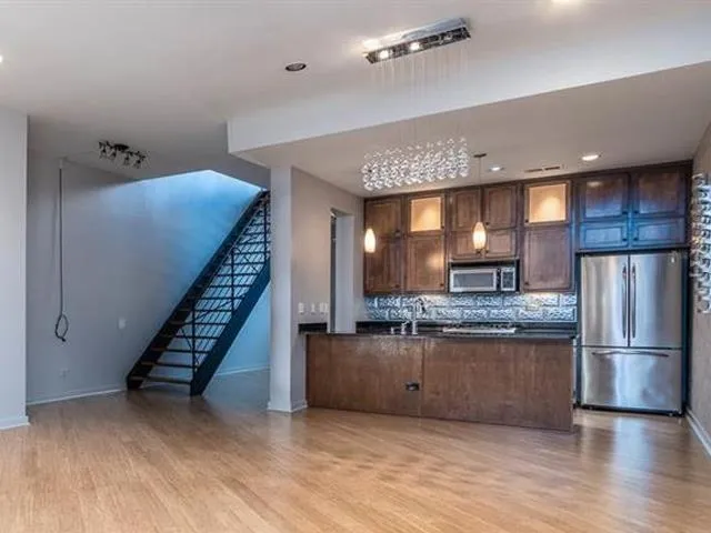 a kitchen with stainless steel appliances granite countertop a refrigerator and a stove top oven