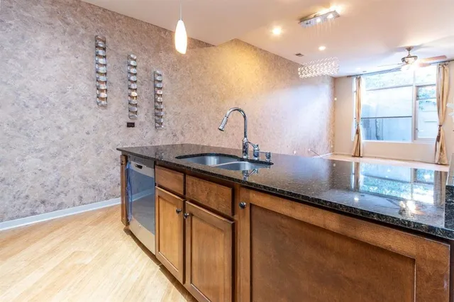 a kitchen with stainless steel appliances granite countertop a sink and a stove