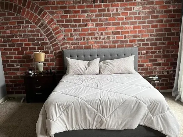 a bedroom with a bed and a black white checkered floor