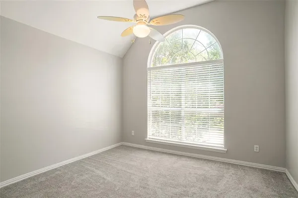 an empty room with a window and a chandelier