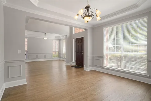 a view of an empty room with window and wooden floor