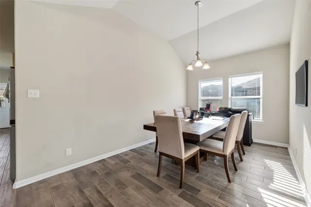 a dining room with furniture a chandelier and wooden floor