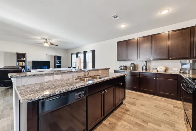 a kitchen with stainless steel appliances granite countertop a sink stove and cabinets
