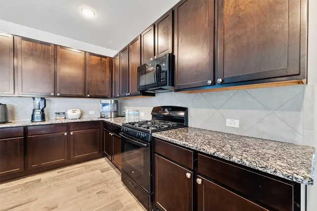 a kitchen with granite countertop stainless steel appliances and wooden cabinets