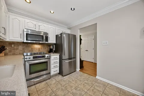 a kitchen with granite countertop a refrigerator and a stove top oven