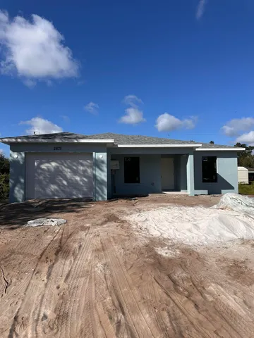a view of a house with a yard and a garage
