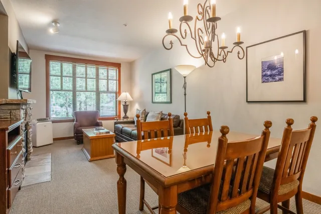 a view of a dining room with furniture a chandelier and wooden floor