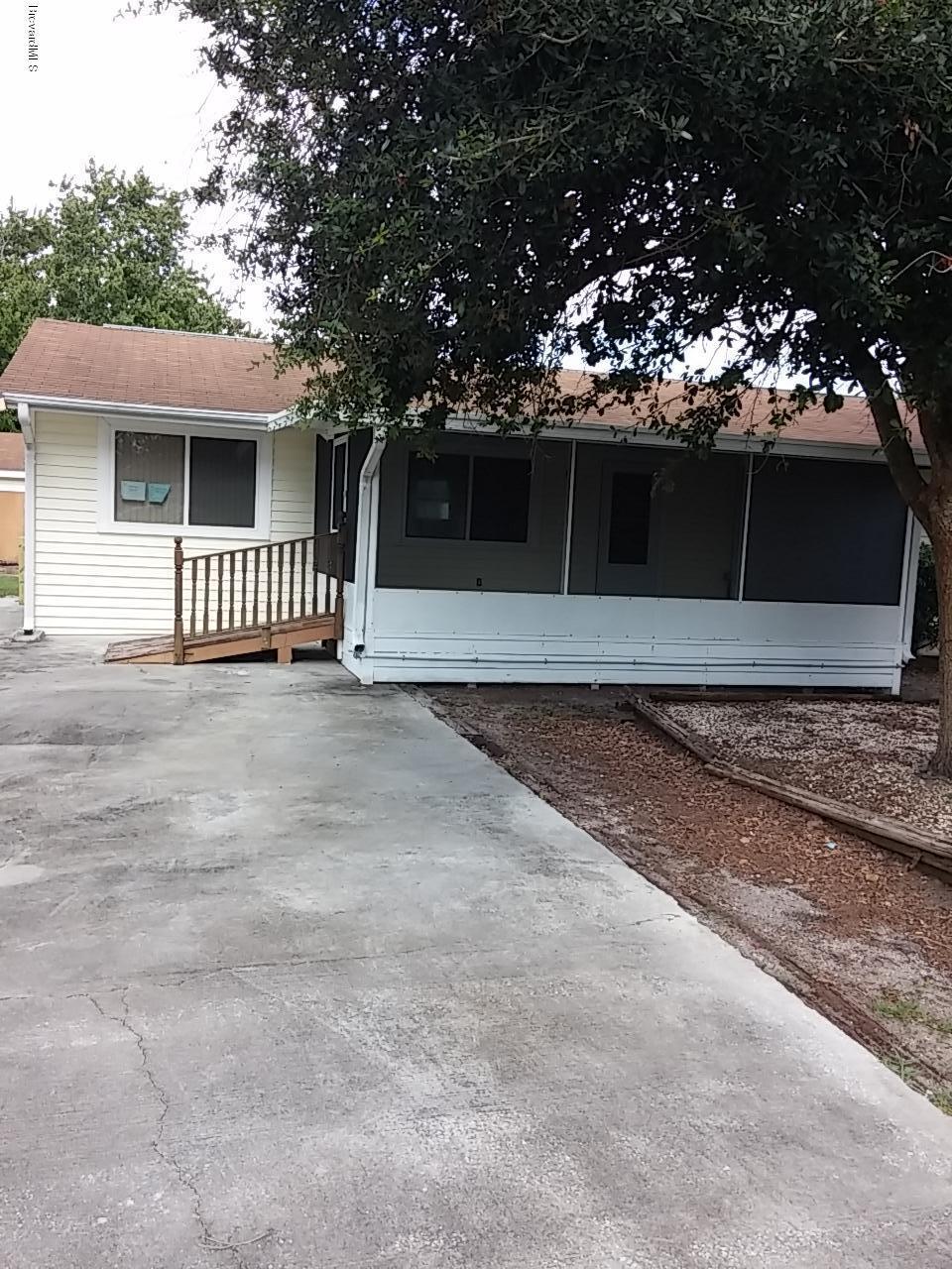 1645 Anson Road Melbourne, FL 32934 - Photo 1 of 21 a front view of a house with a yard and garage