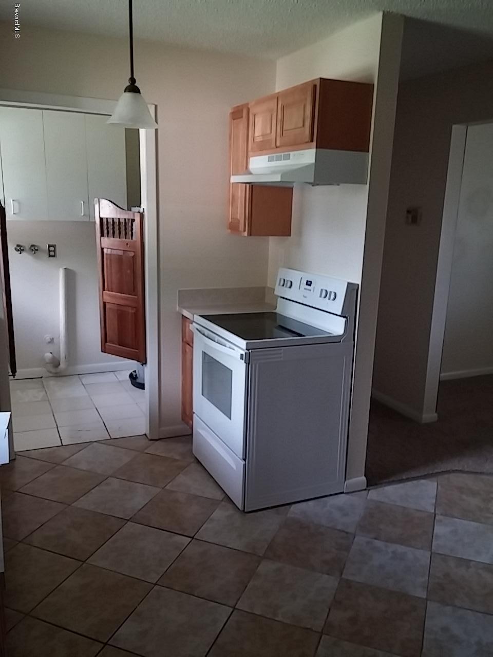 1645 Anson Road Melbourne, FL 32934 - Photo 4 of 21 a kitchen with a stove and a microwave