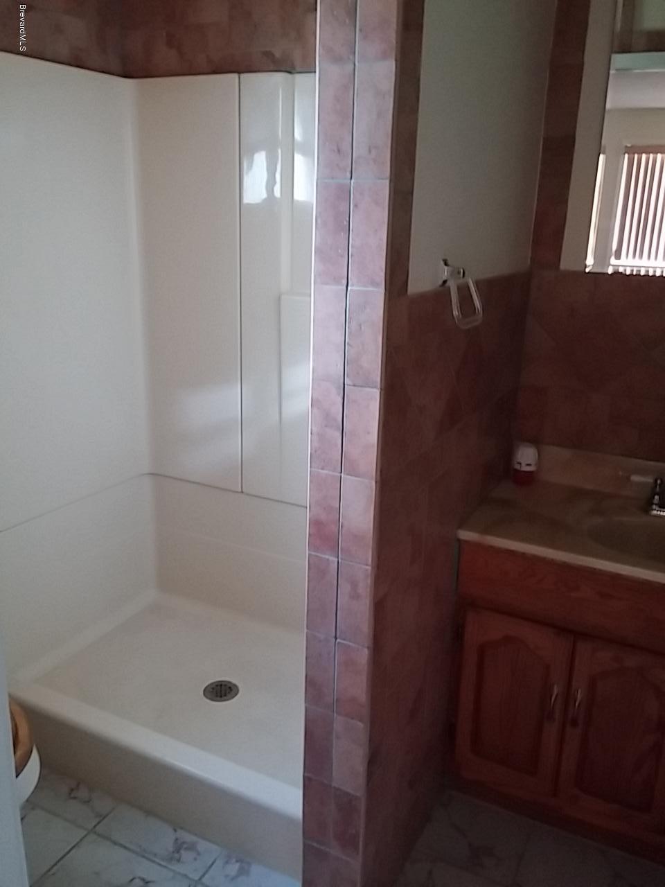 1645 Anson Road Melbourne, FL 32934 - Photo 8 of 21 a bathroom with a shower