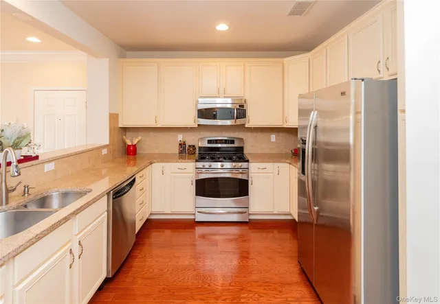 a kitchen with stainless steel appliances a refrigerator and a stove top oven