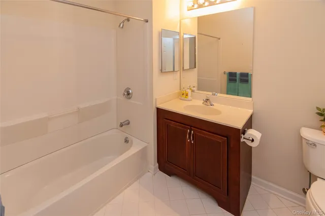 a bathroom with a sink a toilet a mirror and shower