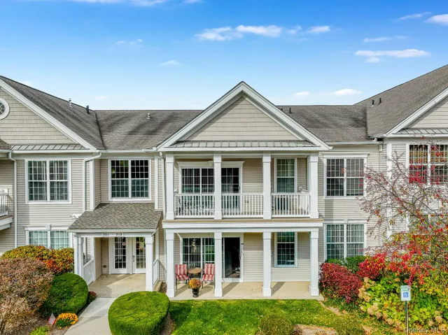 front view of a brick house with a yard