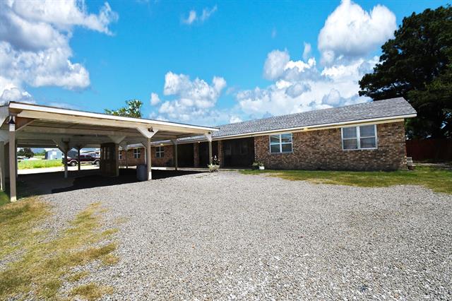 107903 South 4570 Road Sallisaw, OK 74955 - Photo 5 of 35 Brick exterior with multiple windows, an attached carport, and a gravel driveway