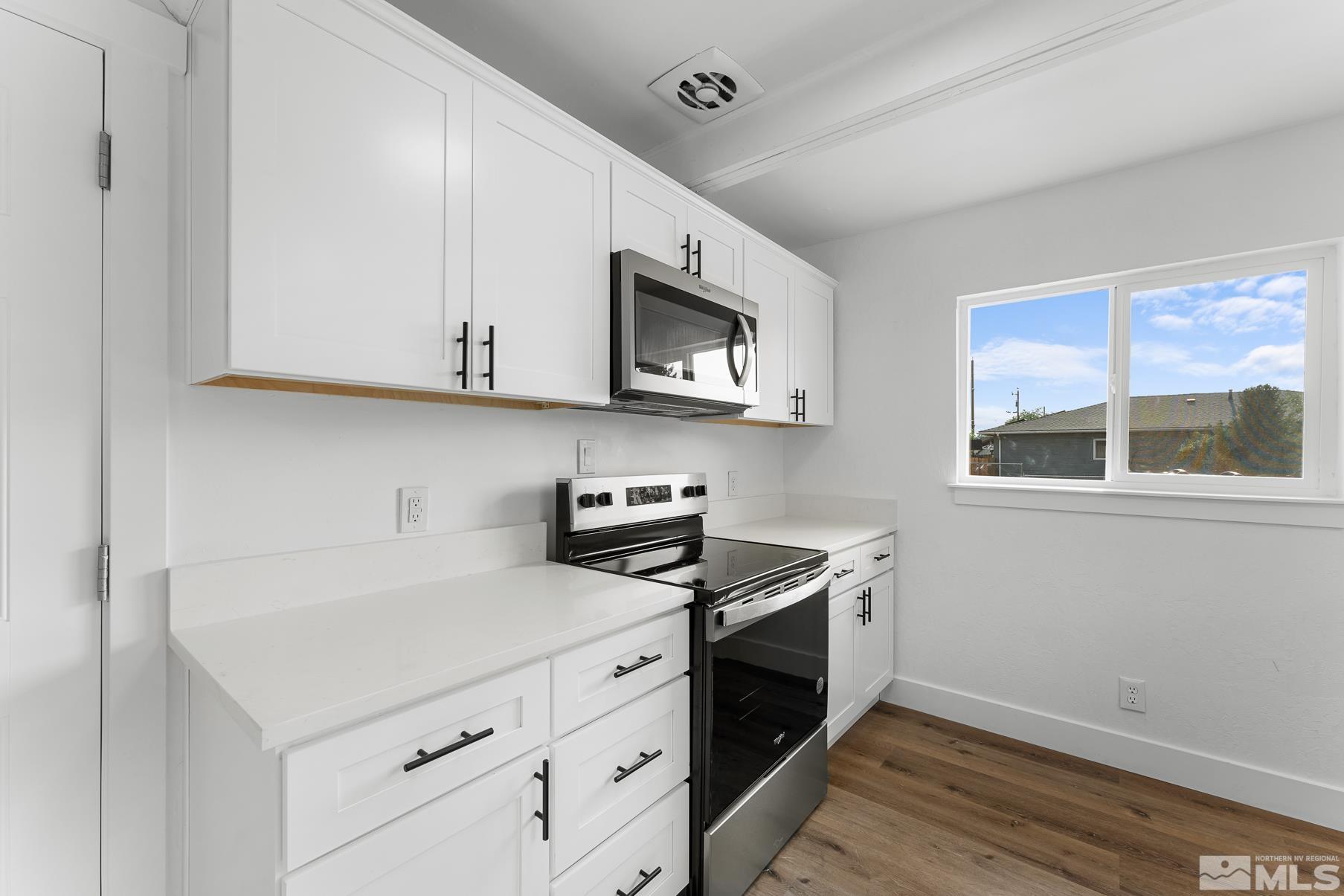 1350 Manhattan Street Reno, NV 89512 - Photo 4 of 18 a kitchen with stainless steel appliances granite countertop a sink stove and microwave