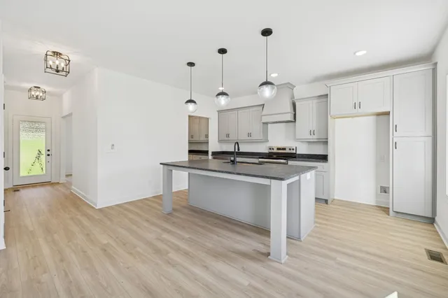 a open kitchen with white cabinets and stainless steel appliances