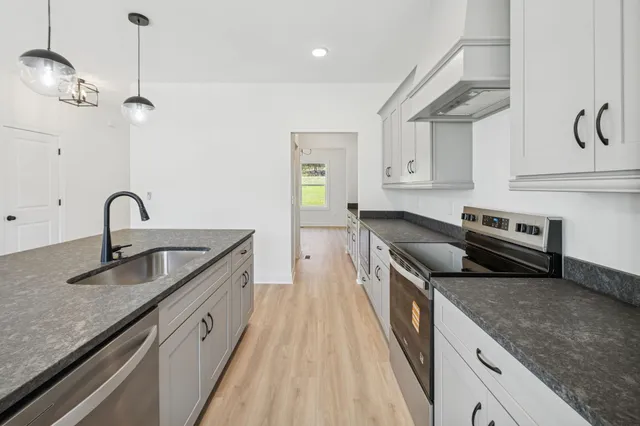 a kitchen with stainless steel appliances granite countertop a sink and stove
