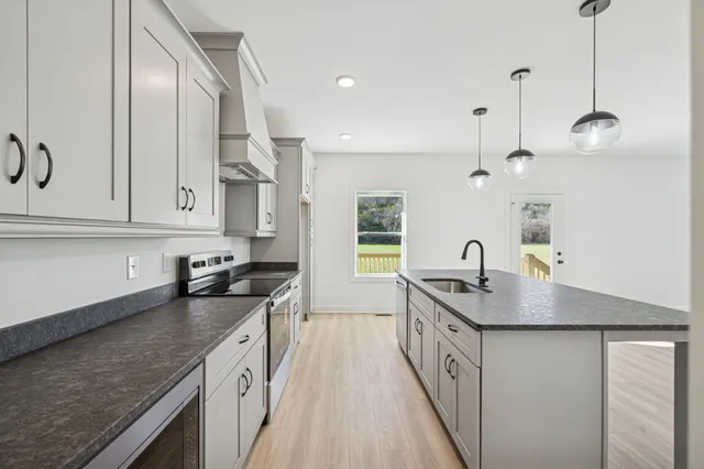 a kitchen with stainless steel appliances granite countertop a sink stove and refrigerator