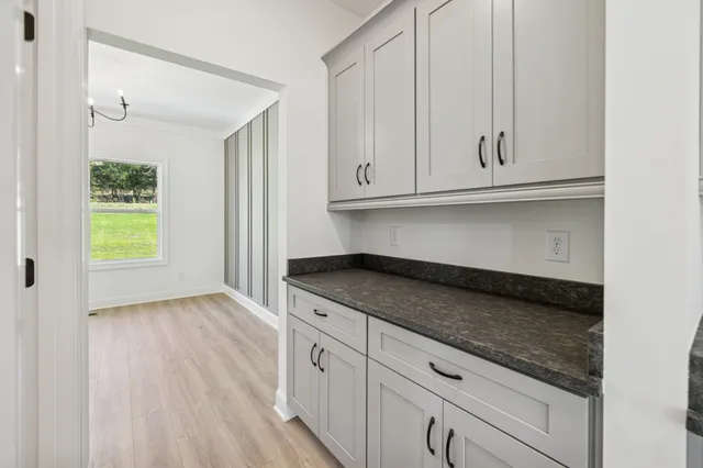 a kitchen with granite countertop a sink and dishwasher with white cabinets