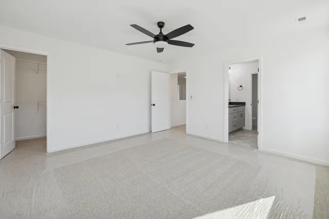 an empty room with closet and ceiling fan