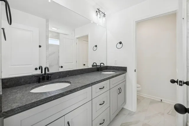a bathroom with a granite countertop sink and a mirror