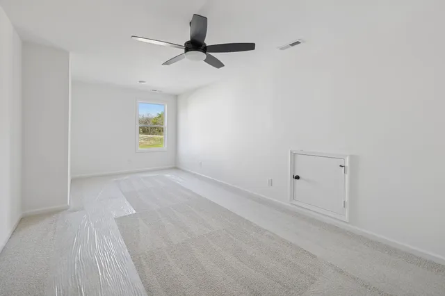 a view of a livingroom with a ceiling fan and window