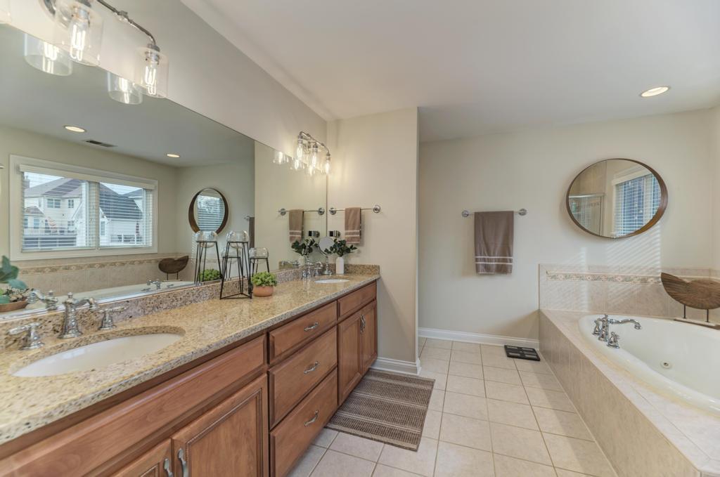 1061 Sean Circle Darien, IL 60561 - Photo 22 of 50 a spacious bathroom with a granite countertop tub a double vanity sink and a large mirror