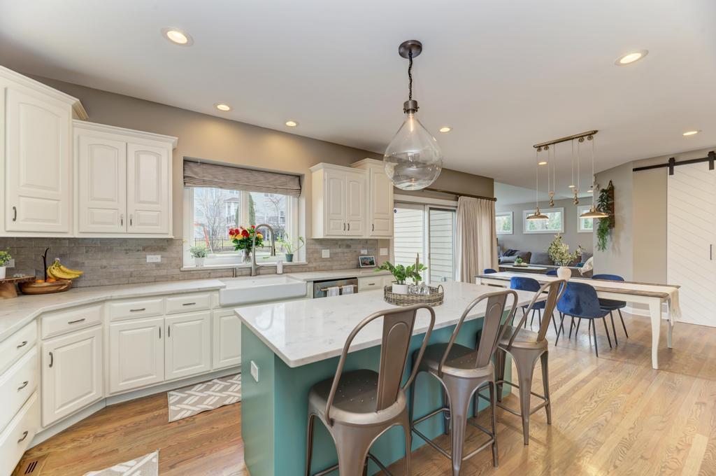 1061 Sean Circle Darien, IL 60561 - Photo 9 of 50 a kitchen with stainless steel appliances kitchen island granite countertop a dining table chairs and white cabinets