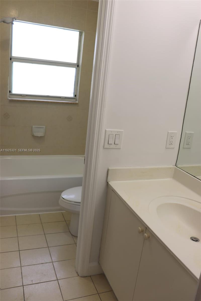2940 Southeast 15th Terrace, Unit 2940 Homestead, FL 33035 - Photo 14 of 28 a bathroom with a sink a toilet and a bathtub