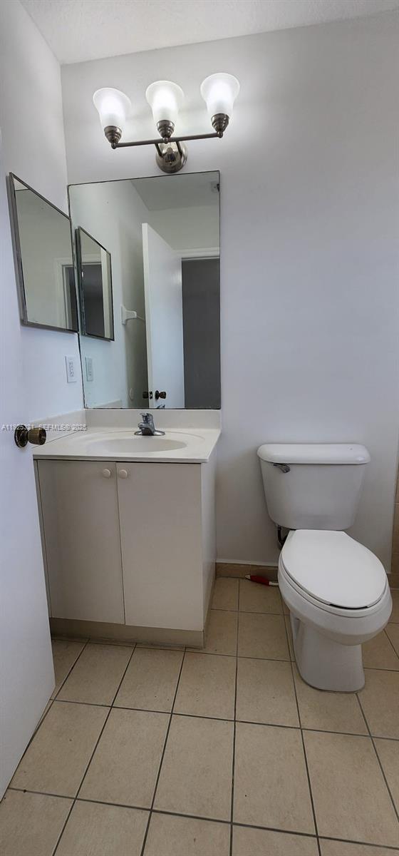 2940 Southeast 15th Terrace, Unit 2940 Homestead, FL 33035 - Photo 20 of 28 a bathroom with a toilet a sink and mirror
