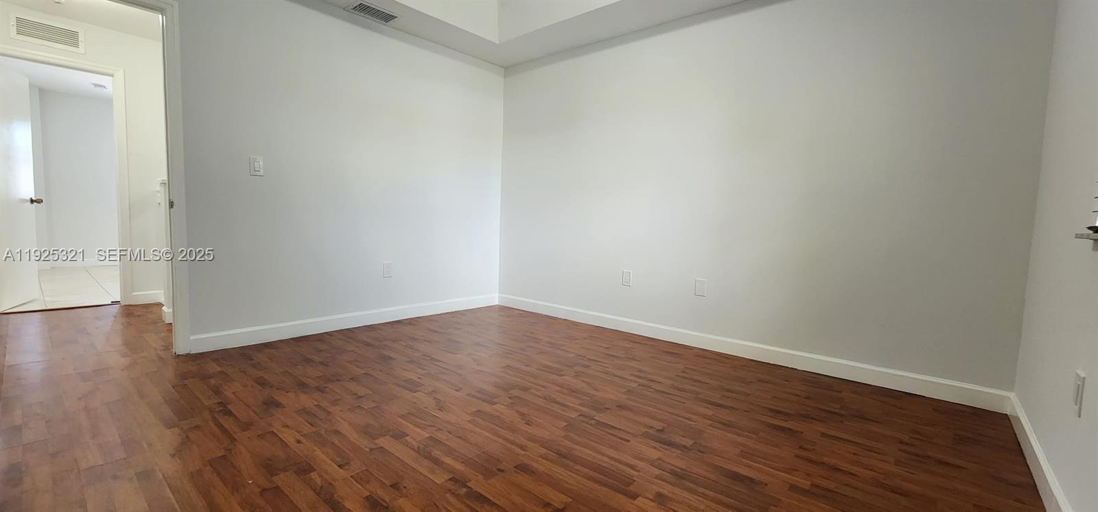 2940 Southeast 15th Terrace, Unit 2940 Homestead, FL 33035 - Photo 9 of 28 a view of an empty room with wooden floor