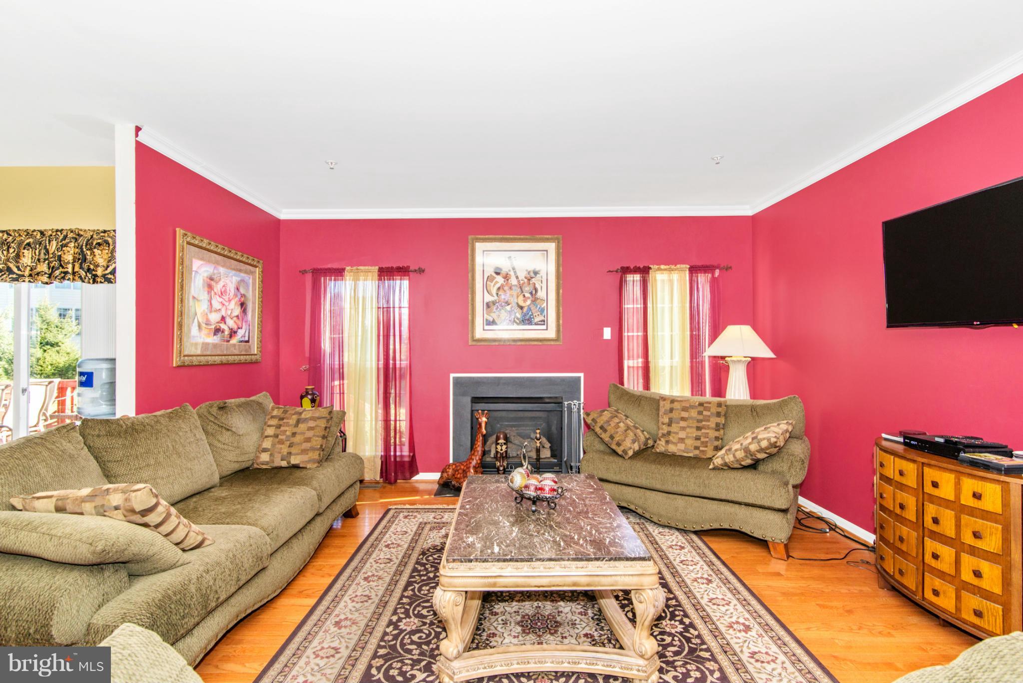 14625 Bubbling Spring Road Boyds, MD 20841 - Photo 11 of 30 a living room with furniture a flat screen tv and a fireplace
