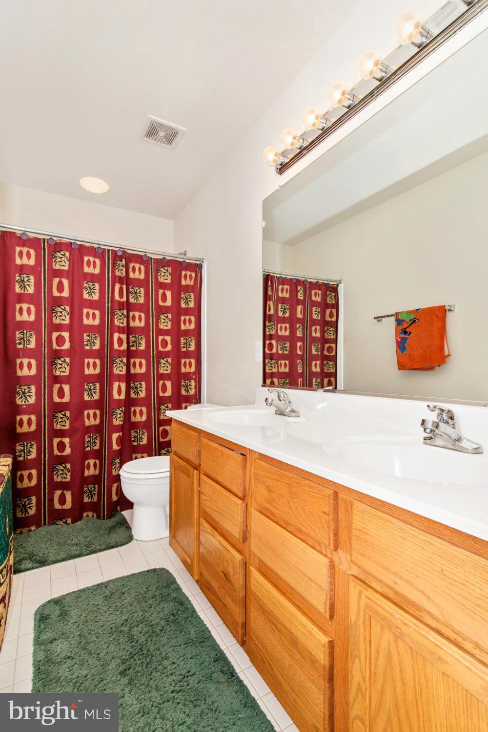 14625 Bubbling Spring Road Boyds, MD 20841 - Photo 23 of 30 a spacious bathroom with a granite countertop sink and a large mirror