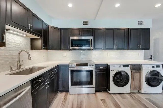 a kitchen with a sink a stove and cabinets