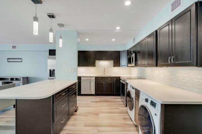 360 Wilma Circle, Unit 6 Riviera Beach, FL 33404 - Photo 7 of 13 a large kitchen with stainless steel appliances granite countertop a sink a stove and a wooden floors