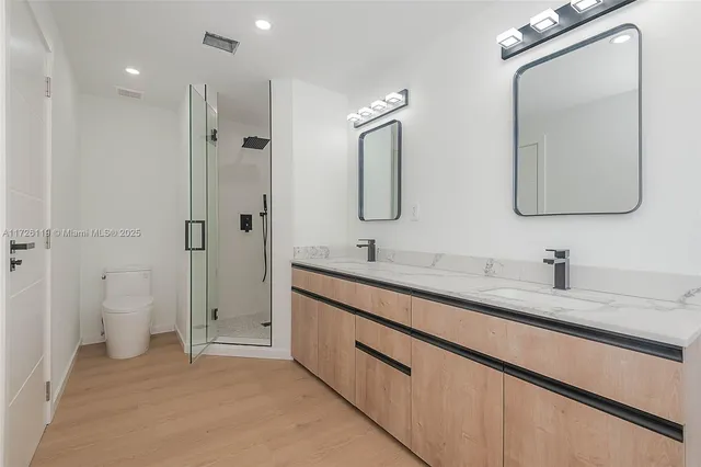 a spacious bathroom with a double vanity sink mirror and toilet