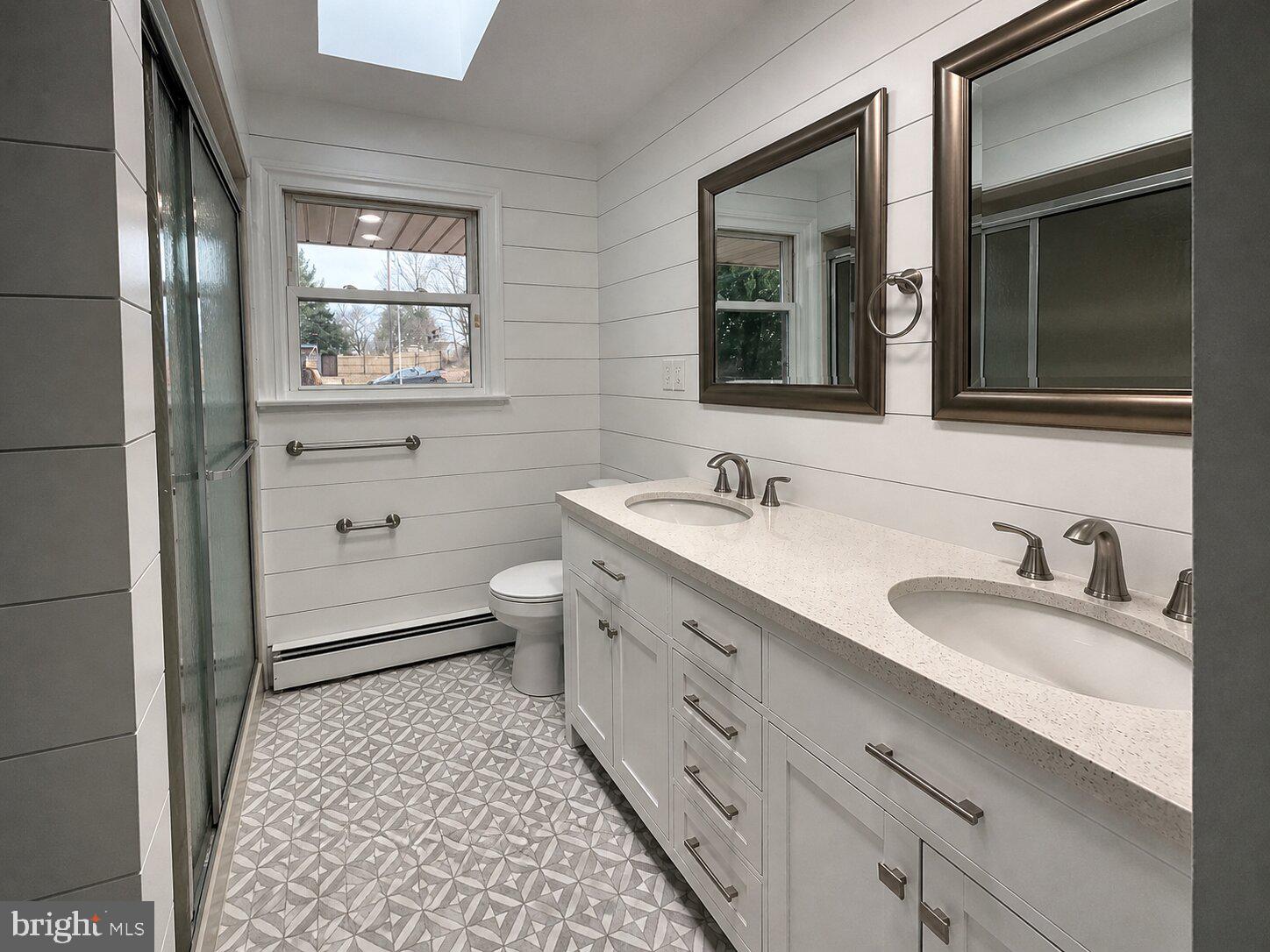 1306 South Township Line Road Royersford, PA 19468 - Photo 2 of 5 a bathroom with a double vanity sink toilet mirror and window