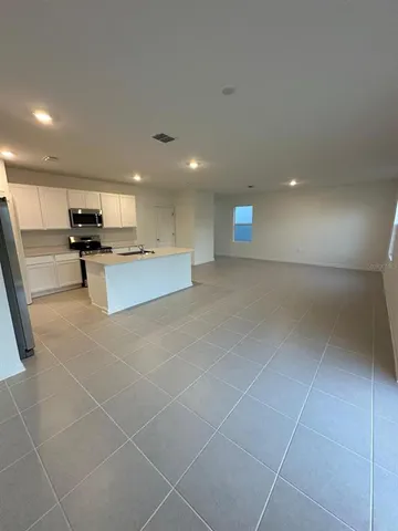 a large kitchen with stainless steel appliances a large counter top a stove and a refrigerator