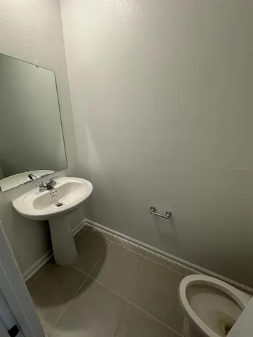 a bathroom with a sink toilet and a mirror