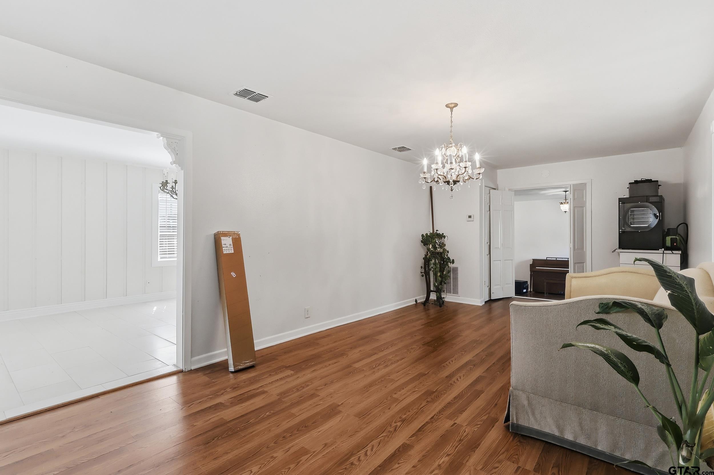 4932 Southeast Acc Road Mount Vernon, TX 75457 - Photo 3 of 35 a living room with furniture a chandelier and a wooden floor