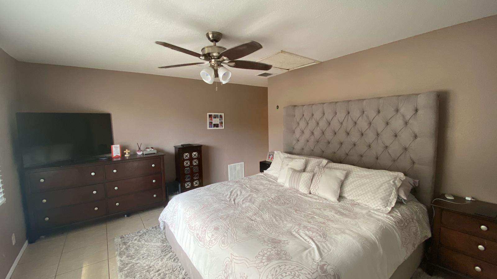 2628 Marcinski Road Jupiter, FL 33477 - Photo 11 of 18 a bedroom with a bed and a chandelier