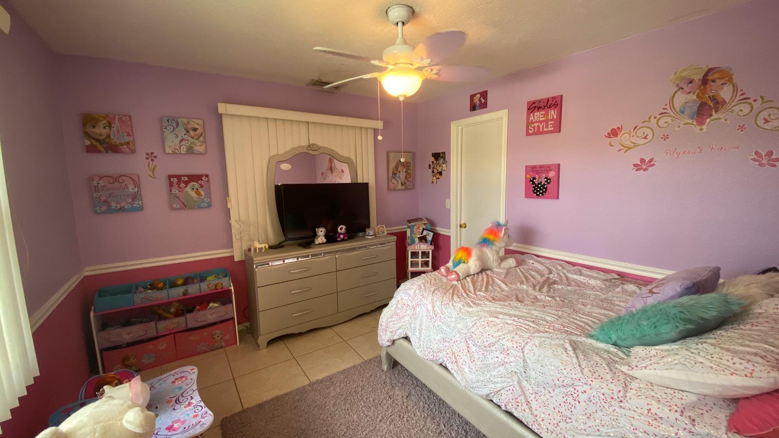 2628 Marcinski Road Jupiter, FL 33477 - Photo 12 of 18 a bedroom with a bed and a flat screen tv