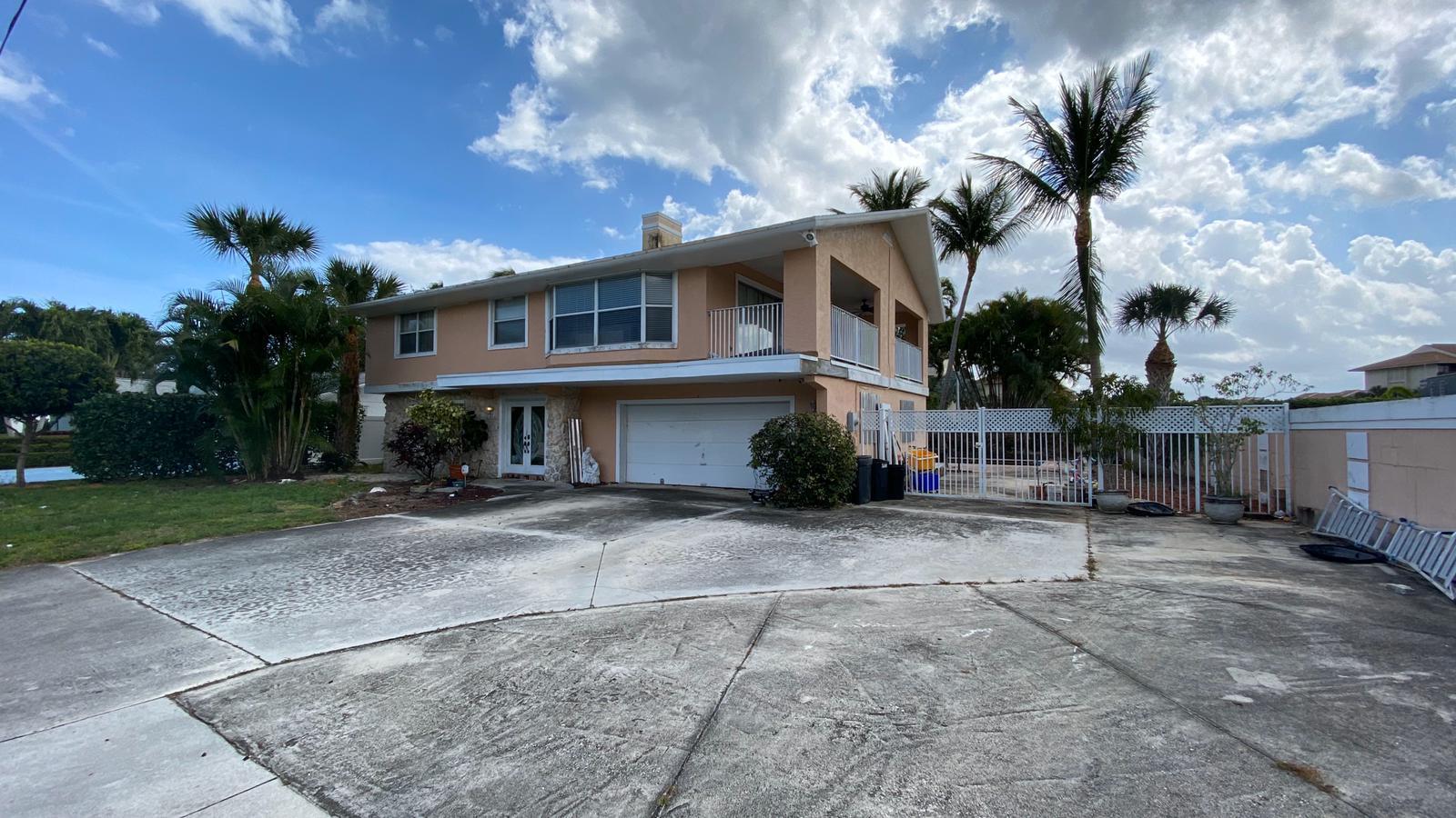 2628 Marcinski Road Jupiter, FL 33477 - Photo 2 of 18 a front view of a house with a yard and garage