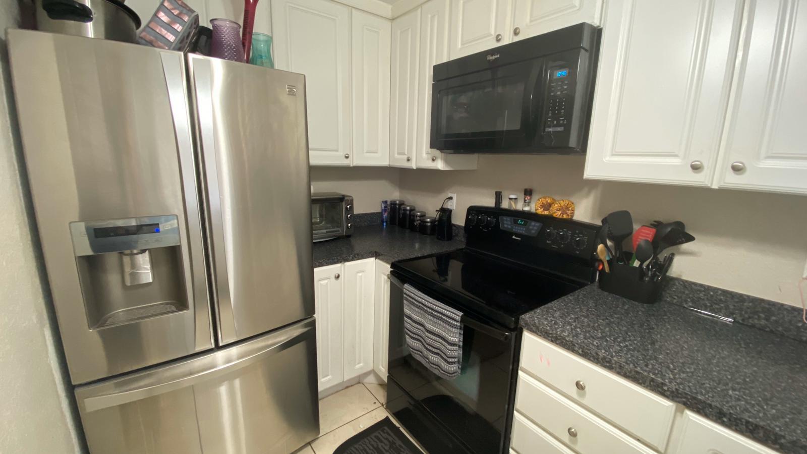 2628 Marcinski Road Jupiter, FL 33477 - Photo 6 of 18 a kitchen with a refrigerator sink and microwave